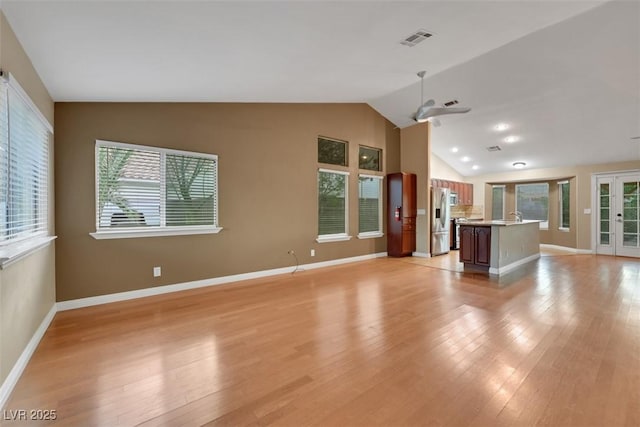 160 Coastal Pier Ct, Henderson, NV 89002 - unfurnished living room with vaulted ceiling, light wood-style flooring, ceiling fan, and french doors