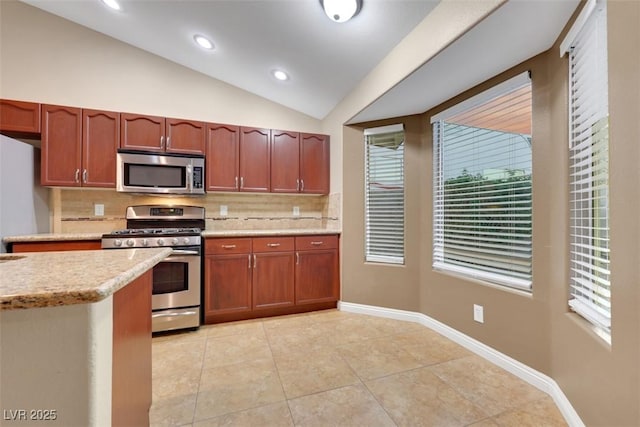 160 Coastal Pier Ct, Henderson, NV 89002 - kitchen featuring appliances with stainless steel finishes, decorative backsplash, lofted ceiling, light tile patterned floors, and recessed lighting