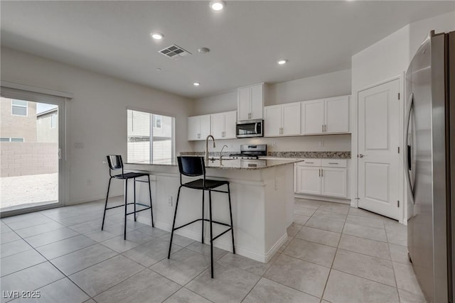 4448 Mahogany Hills Ave, Las Vegas, NV 89141 - kitchen with appliances with stainless steel finishes, healthy amount of natural light, an island with sink, white cabinetry, and recessed lighting