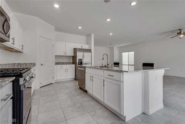 4448 Mahogany Hills Ave, Las Vegas, NV 89141 - kitchen featuring a sink, stainless steel appliances, light stone countertops, white cabinetry, and recessed lighting
