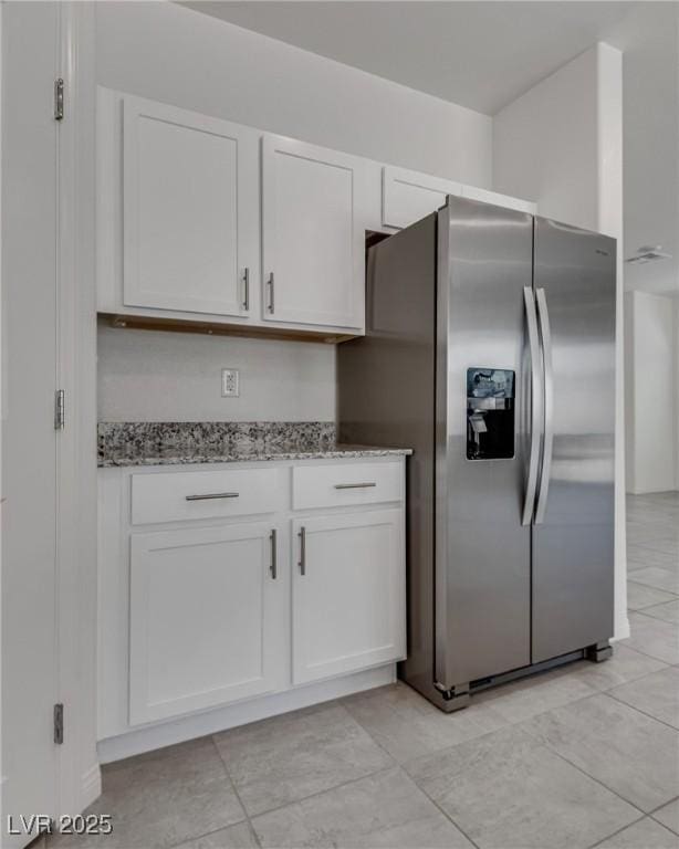 4448 Mahogany Hills Ave, Las Vegas, NV 89141 - kitchen featuring stainless steel refrigerator with ice dispenser, light stone countertops, white cabinetry, and light tile patterned floors