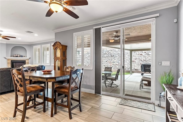 3811 Queen Elizabeth Ct, Laughlin, NV 89029 - dining room featuring ceiling fan, healthy amount of natural light, ornamental molding, a glass covered fireplace, and recessed lighting