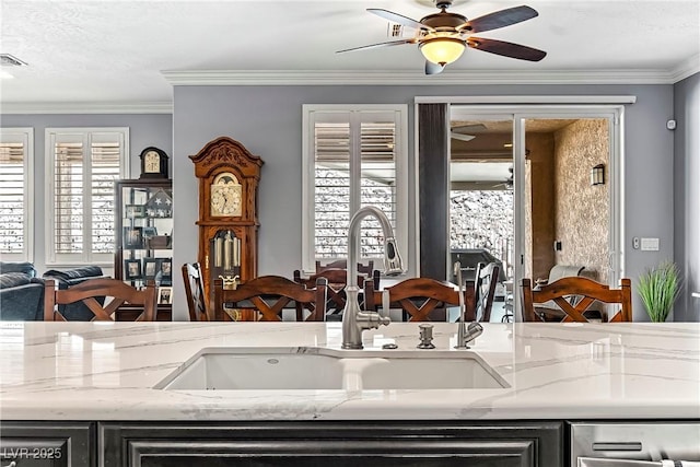 3811 Queen Elizabeth Ct, Laughlin, NV 89029 - kitchen featuring a sink, a ceiling fan, light stone counters, stainless steel dishwasher, and open floor plan