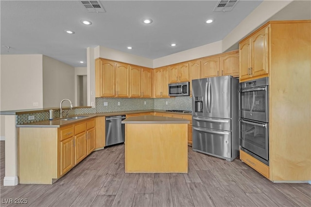 1717 Double Arch Ct, Las Vegas, NV 89128 - kitchen featuring stainless steel appliances, light wood-style floors, a peninsula, light brown cabinetry, and recessed lighting