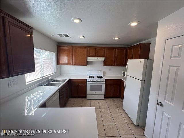 7464 Edgecove Ct, Las Vegas, NV 89139 - kitchen featuring white appliances, under cabinet range hood, a sink, light countertops, and recessed lighting