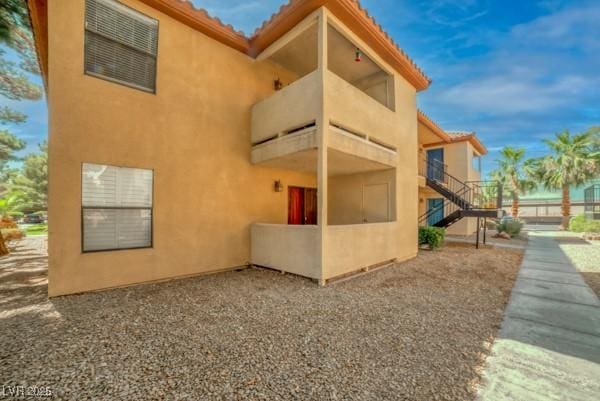 3135 S Mojave Rd Unit 113, Las Vegas, NV 89121 - view of side of property featuring stucco siding, stairs, and a tile roof