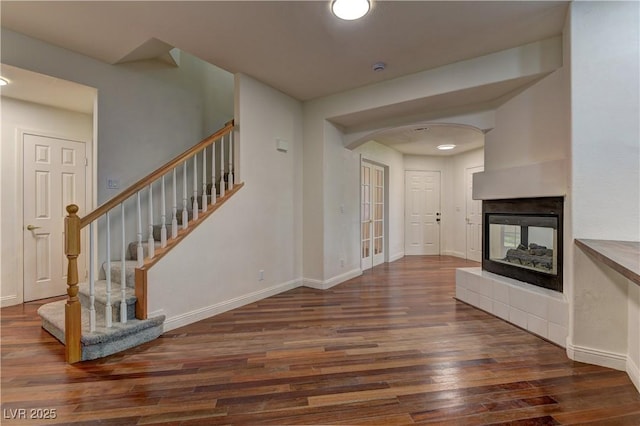 108 Broken Rock Dr, Henderson, NV 89074 - unfurnished living room with wood finished floors, arched walkways, stairway, baseboards, and a multi sided fireplace