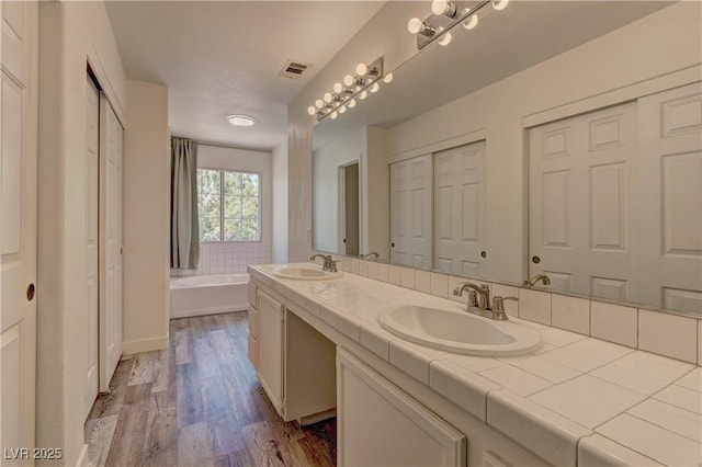 108 Broken Rock Dr, Henderson, NV 89074 - full bath with double vanity, wood finished floors, a garden tub, and a closet