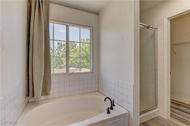 108 Broken Rock Dr, Henderson, NV 89074 - bathroom featuring a bath, a stall shower, a walk in closet, and wood finished floors
