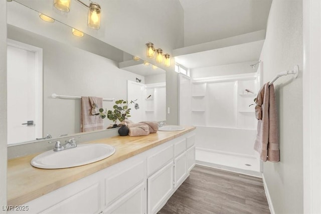 3053 Anchor Chain Dr, Las Vegas, NV 89128 - bathroom featuring double vanity, walk in shower, and wood finished floors
