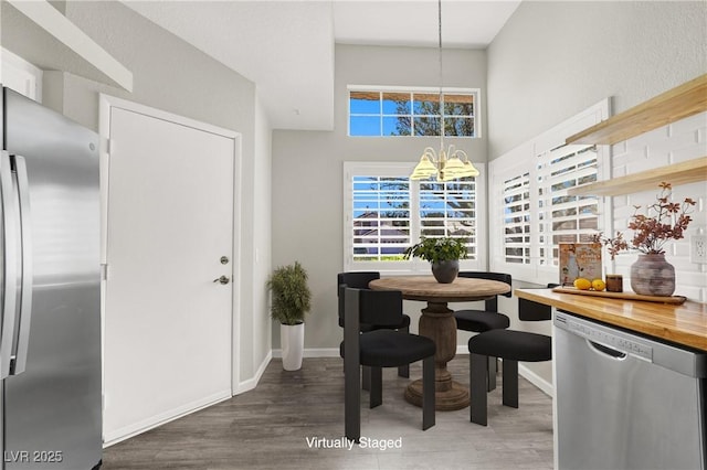 3053 Anchor Chain Dr, Las Vegas, NV 89128 - dining space with a chandelier, wood finished floors, baseboards, and a high ceiling