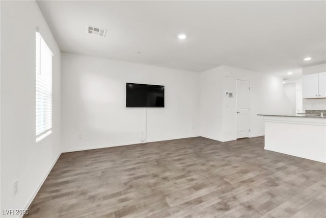 7977 Whisper Words Ave, Las Vegas, NV 89113 - unfurnished living room with light wood-style floors, recessed lighting, and baseboards