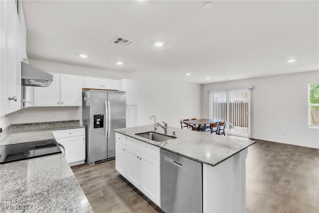 7977 Whisper Words Ave, Las Vegas, NV 89113 - kitchen with stainless steel appliances, a sink, wall chimney exhaust hood, light wood-type flooring, and an island with sink