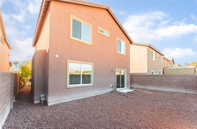 1512 Groom Ave, North Las Vegas, NV 89081 - rear view of property with stucco siding, a fenced backyard, and a tiled roof