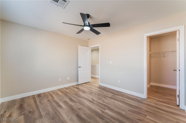 1512 Groom Ave, North Las Vegas, NV 89081 - unfurnished bedroom with wood finished floors, a walk in closet, baseboards, and a closet