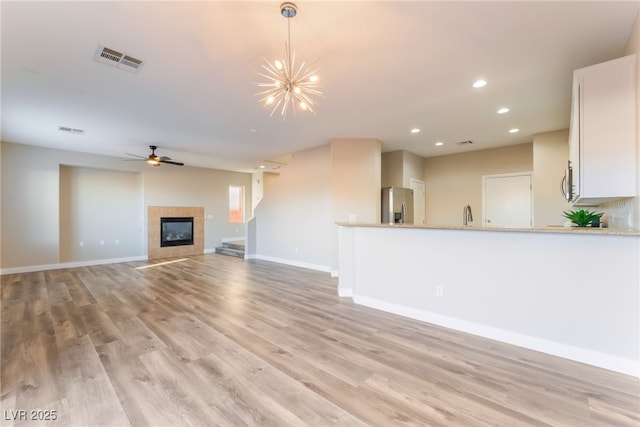 1512 Groom Ave, North Las Vegas, NV 89081 - unfurnished living room with light wood-style floors, a fireplace, recessed lighting, baseboards, and a chandelier