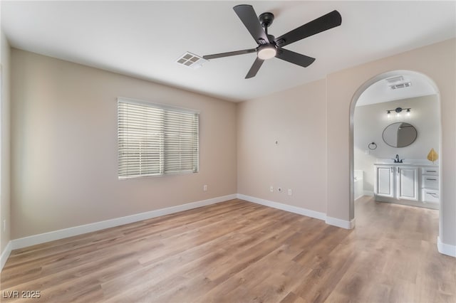 1512 Groom Ave, North Las Vegas, NV 89081 - empty room with arched walkways, ceiling fan, light wood-style flooring, and baseboards