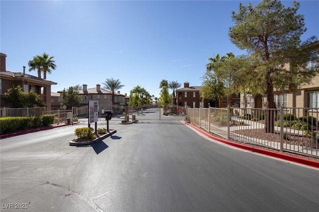 10291 Delta View Ct Unit 101, Las Vegas, NV 89129 - view of asphalt street featuring a residential view, a gated entry, a gate, and curbs