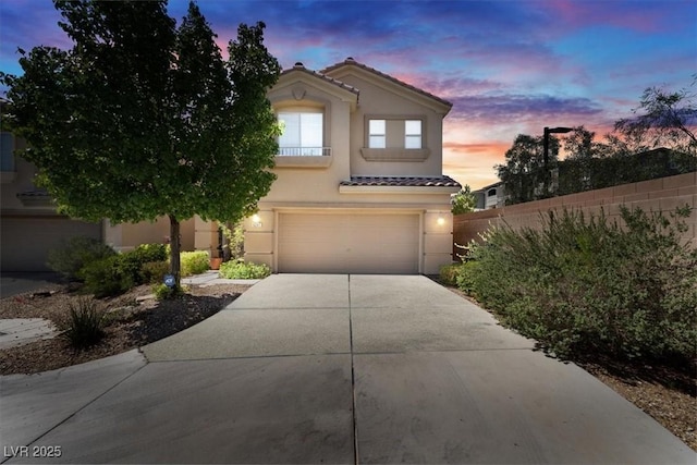 6247 Sugartree Ave, Las Vegas, NV 89141 - mediterranean / spanish home featuring a tile roof, stucco siding, driveway, and a garage