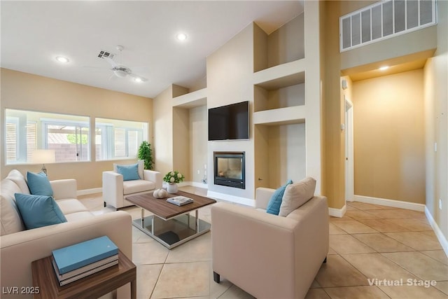 11082 Sospel Pl, Las Vegas, NV 89141 - living room featuring baseboards, a glass covered fireplace, light tile patterned floors, built in features, and recessed lighting