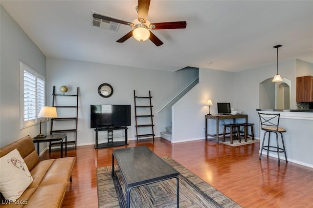 9362 Straw Hays St Unit 103, Las Vegas, NV 89178 - living room featuring ceiling fan, wood finished floors, arched walkways, stairway, and baseboards