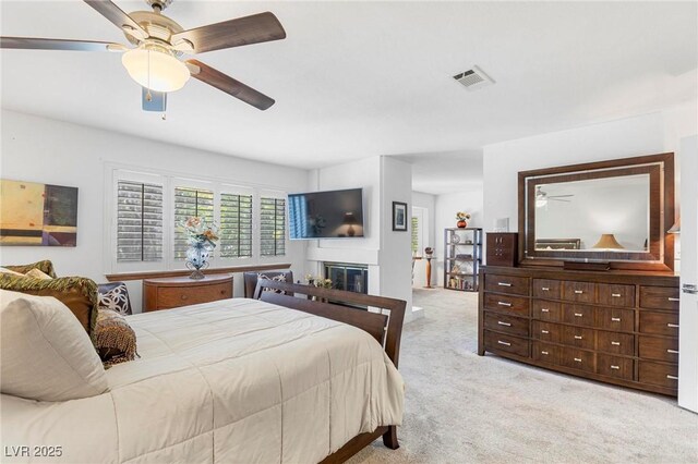 2222 Lucerne Ct, Henderson, NV 89014 - carpeted bedroom with a glass covered fireplace and a ceiling fan
