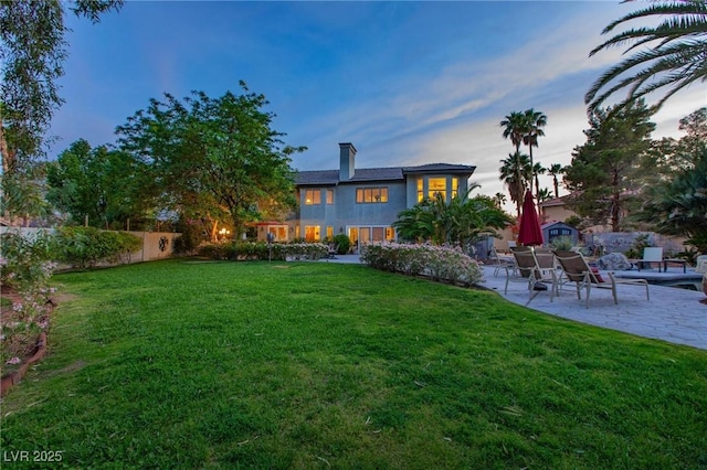 2222 Lucerne Ct, Henderson, NV 89014 - back of house at dusk featuring a patio area and a chimney