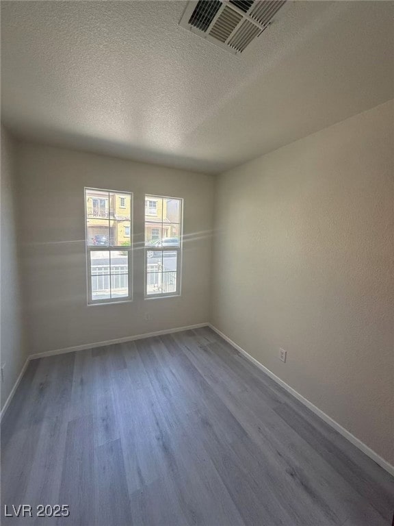 7469 Margollini St, Las Vegas, NV 89148 - unfurnished room with wood finished floors, a textured ceiling, and baseboards