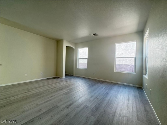 7469 Margollini St, Las Vegas, NV 89148 - empty room with arched walkways, dark wood finished floors, and baseboards