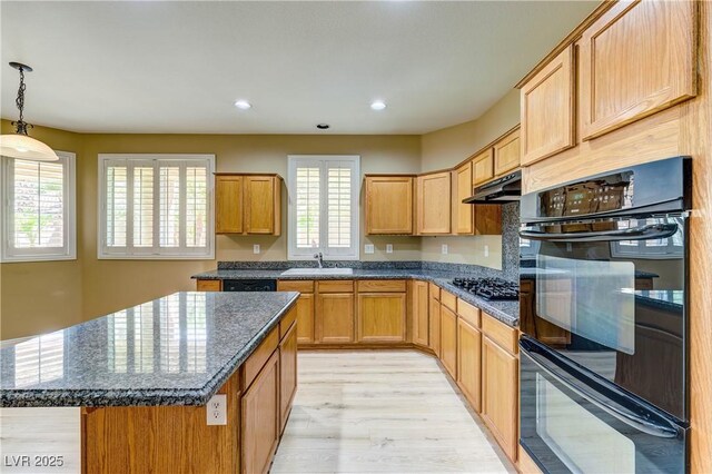 11478 Bargetto Ct, Las Vegas, NV 89141 - kitchen featuring black appliances, light wood-style floors, under cabinet range hood, dark stone countertops, and recessed lighting
