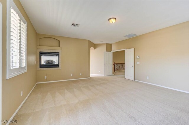 11478 Bargetto Ct, Las Vegas, NV 89141 - unfurnished room featuring baseboards, light carpet, and a glass covered fireplace