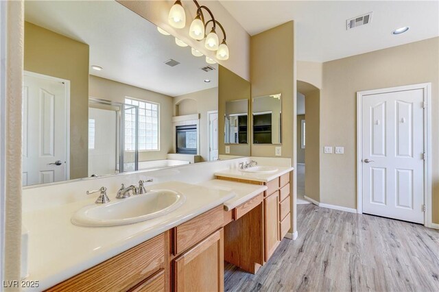 11478 Bargetto Ct, Las Vegas, NV 89141 - bathroom featuring double vanity, wood finished floors, an enclosed shower, baseboards, and a tub