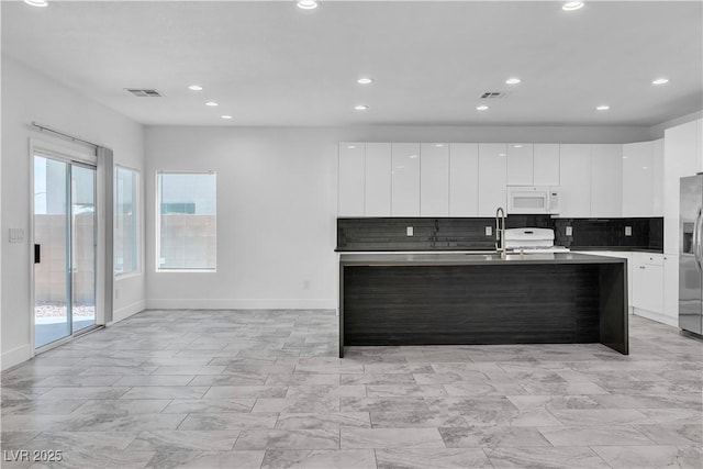 4016 Owlshead Mountain St, Las Vegas, NV 89129 - kitchen with modern cabinets, white microwave, decorative backsplash, and recessed lighting