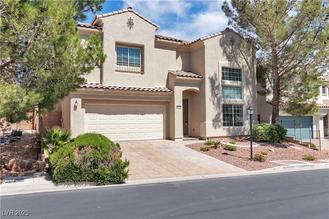 4016 Owlshead Mountain St, Las Vegas, NV 89129 - mediterranean / spanish house with a tiled roof, decorative driveway, an attached garage, and stucco siding