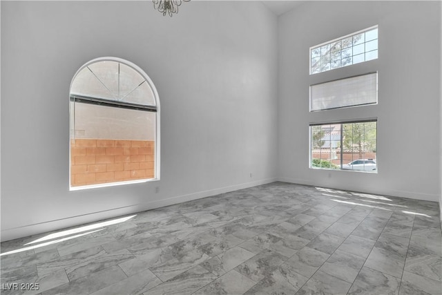 4016 Owlshead Mountain St, Las Vegas, NV 89129 - spare room featuring marble look tile flooring, a high ceiling, and baseboards