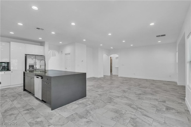 4016 Owlshead Mountain St, Las Vegas, NV 89129 - kitchen with appliances with stainless steel finishes, arched walkways, modern cabinets, dark countertops, and white cabinets