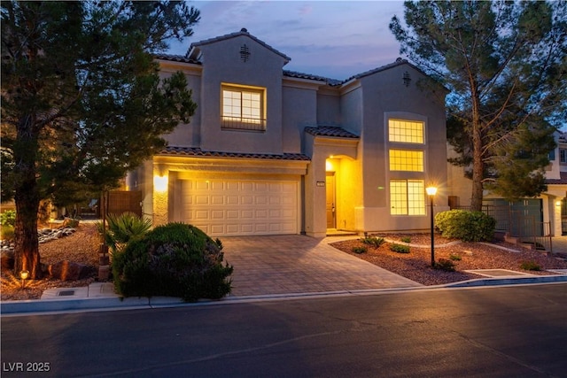4016 Owlshead Mountain St, Las Vegas, NV 89129 - mediterranean / spanish house featuring a tile roof, driveway, an attached garage, and stucco siding