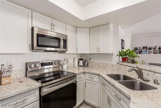 8600 W Charleston Blvd Unit 2187, Las Vegas, NV 89117 - kitchen with stainless steel appliances, a sink, white cabinetry, light stone counters, and ornamental molding