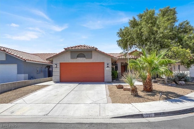 1225 Stonesthrow Cir, North Las Vegas, NV 89031 - mediterranean / spanish-style house featuring a garage, driveway, stucco siding, and a tile roof