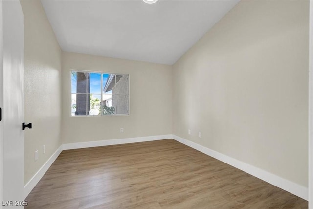 1225 Stonesthrow Cir, North Las Vegas, NV 89031 - spare room featuring wood finished floors, baseboards, and lofted ceiling