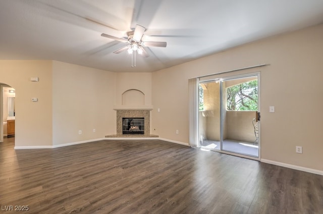 8737 Red Brook Dr Unit 204, Las Vegas, NV 89128 - unfurnished living room with a ceiling fan, dark wood-style flooring, arched walkways, a glass covered fireplace, and baseboards