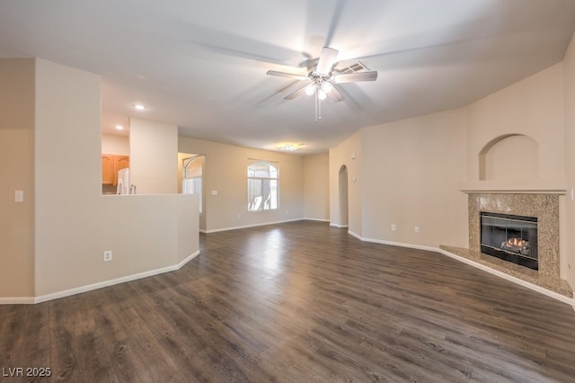 8737 Red Brook Dr Unit 204, Las Vegas, NV 89128 - unfurnished living room with ceiling fan, a fireplace, arched walkways, dark wood-style flooring, and baseboards