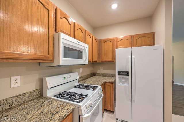 8737 Red Brook Dr Unit 204, Las Vegas, NV 89128 - kitchen with white appliances, light stone countertops, brown cabinets, and recessed lighting