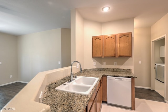 8737 Red Brook Dr Unit 204, Las Vegas, NV 89128 - kitchen featuring white dishwasher, a sink, washer / dryer, and light wood-style flooring
