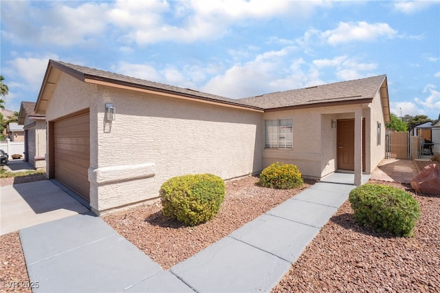 5751 Mabel Rd, Las Vegas, NV 89110 - view of home's exterior featuring driveway, stucco siding, a gate, and a garage