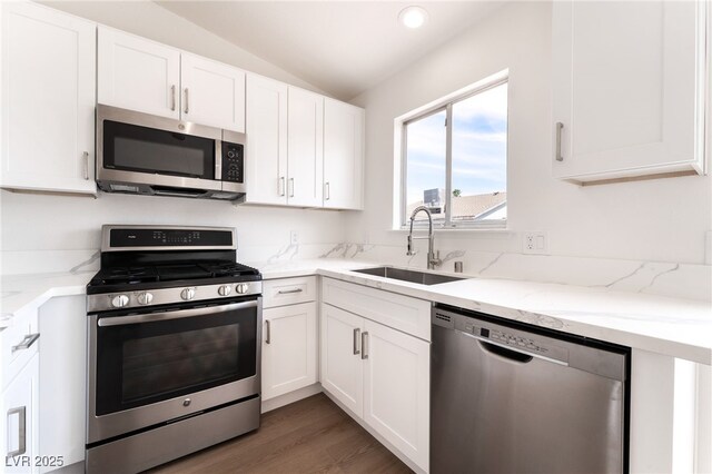 5751 Mabel Rd, Las Vegas, NV 89110 - kitchen with stainless steel appliances, a sink, lofted ceiling, white cabinetry, and light stone countertops