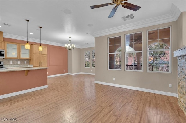 9975 Sand Key St, Las Vegas, NV 89178 - kitchen featuring stainless steel microwave, a chandelier, light wood-style flooring, a kitchen bar, and glass insert cabinets