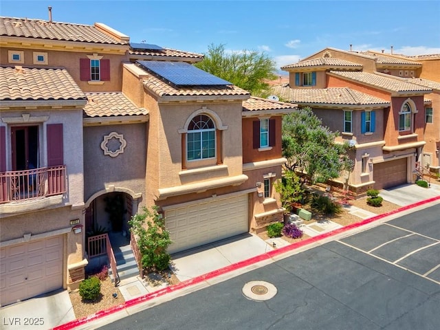 9975 Sand Key St, Las Vegas, NV 89178 - view of front of house with an attached garage, solar panels, stucco siding, a tile roof, and driveway