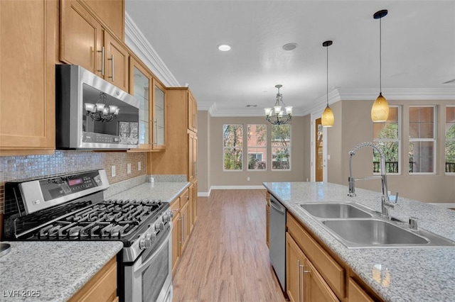 9975 Sand Key St, Las Vegas, NV 89178 - kitchen with stainless steel appliances, a chandelier, light wood-style floors, crown molding, and backsplash