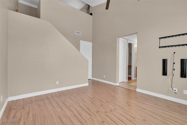 9975 Sand Key St, Las Vegas, NV 89178 - unfurnished living room featuring wood finished floors, a high ceiling, and crown molding
